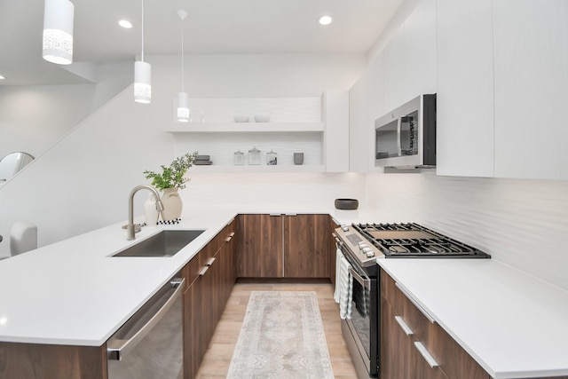 4020 Boho Ln, Houston, TX 77045 - kitchen with stainless steel appliances, modern cabinets, a sink, a peninsula, and recessed lighting