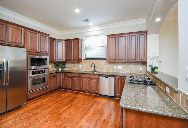321 W 26th St Unit A, Houston, TX 77008 - kitchen with stainless steel appliances, a sink, ornamental molding, stone countertops, and backsplash