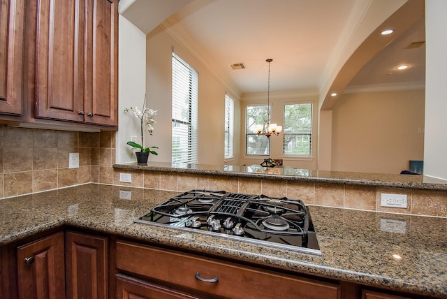 321 W 26th St Unit A, Houston, TX 77008 - kitchen with black gas cooktop, crown molding, brown cabinetry, a chandelier, and decorative backsplash