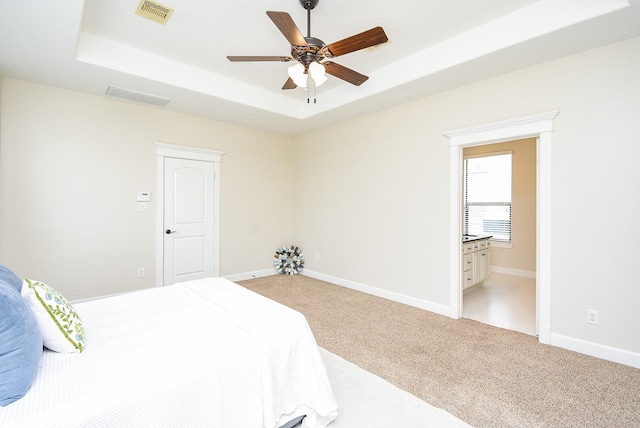 321 W 26th St Unit A, Houston, TX 77008 - bedroom with a raised ceiling, light colored carpet, baseboards, a ceiling fan, and ensuite bathroom