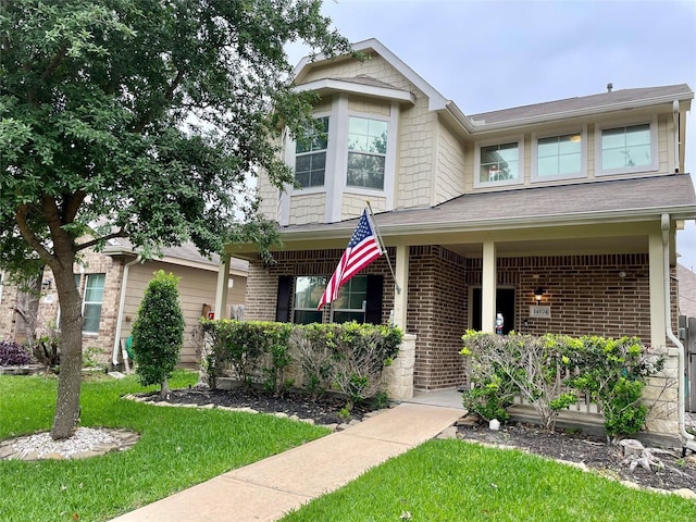 14574 Empanada Dr, Houston, TX 77083 - view of front facade featuring brick siding, a porch, and a front lawn