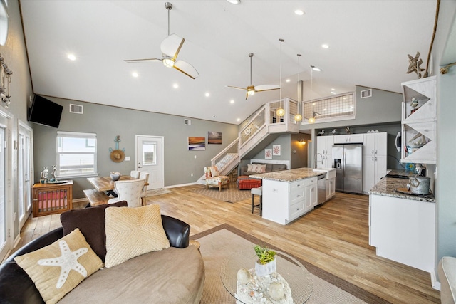 219 Bora Bora Dr, Tiki Island, TX 77554 - living room with high vaulted ceiling, ceiling fan, light wood-style floors, and recessed lighting