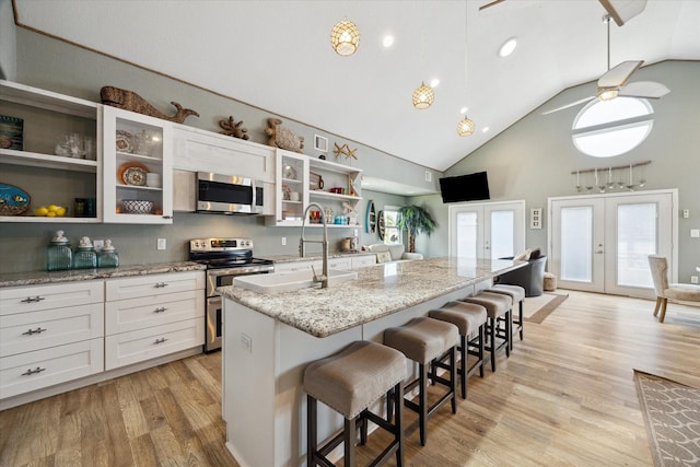 219 Bora Bora Dr, Tiki Island, TX 77554 - kitchen featuring open shelves, appliances with stainless steel finishes, french doors, a breakfast bar, and high vaulted ceiling
