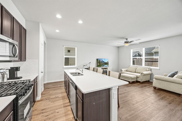 3919 Faletti Dr, Katy, TX 77493 - kitchen with appliances with stainless steel finishes, dark brown cabinets, light wood-style flooring, tasteful backsplash, and recessed lighting