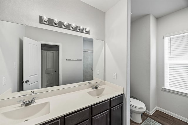 3919 Faletti Dr, Katy, TX 77493 - full bath featuring double vanity, toilet, wood finished floors, baseboards, and plenty of natural light