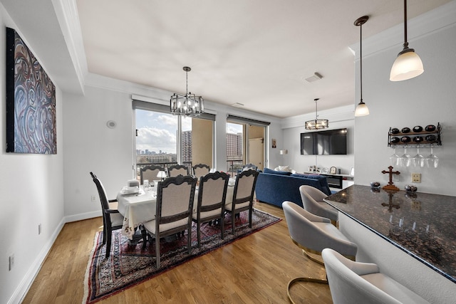 3333 Allen Pkwy Unit 908, Houston, TX 77019 - dining space featuring a chandelier, wood finished floors, baseboards, and ornamental molding