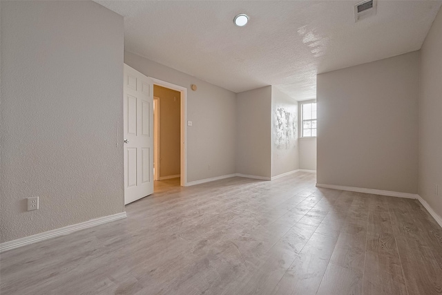 8621 Rustling Lvs Dr, Houston, TX 77083 - unfurnished room featuring light wood-style floors, a textured ceiling, and baseboards