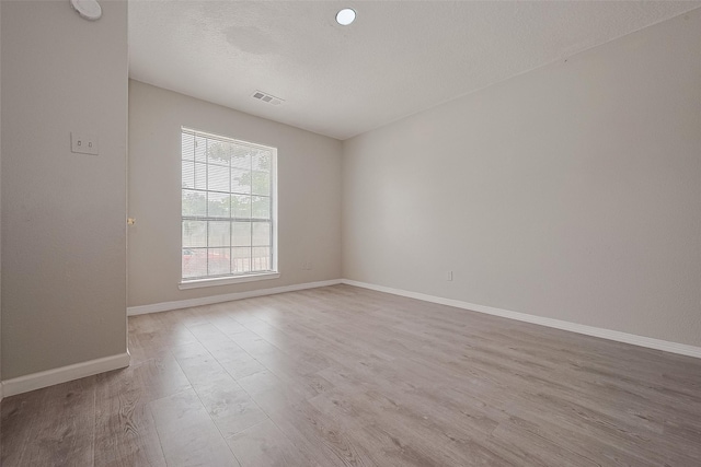 8621 Rustling Lvs Dr, Houston, TX 77083 - unfurnished room featuring wood finished floors, baseboards, a textured ceiling, and a smoke detector