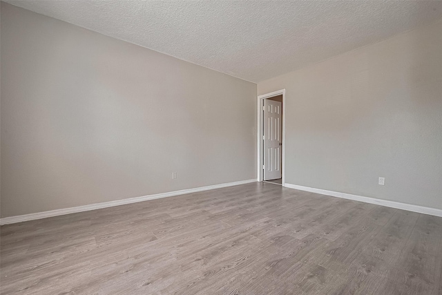 8621 Rustling Lvs Dr, Houston, TX 77083 - spare room with wood finished floors, baseboards, and a textured ceiling