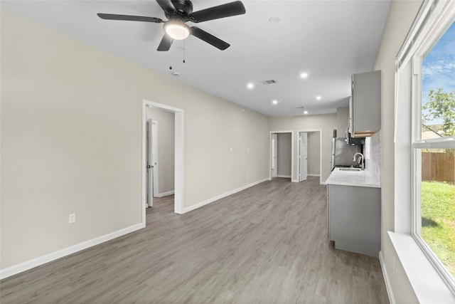 8402 Bassett St, Houston, TX 77051 - unfurnished living room with a sink, light wood-style floors, baseboards, recessed lighting, and ceiling fan