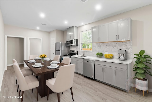 8402 Bassett St, Houston, TX 77051 - kitchen with appliances with stainless steel finishes, a sink, gray cabinets, tasteful backsplash, and recessed lighting