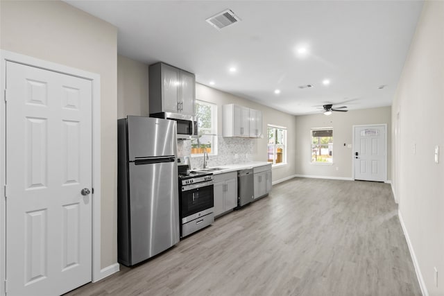 8402 Bassett St, Houston, TX 77051 - kitchen featuring appliances with stainless steel finishes, a sink, baseboards, light wood-style flooring, and recessed lighting