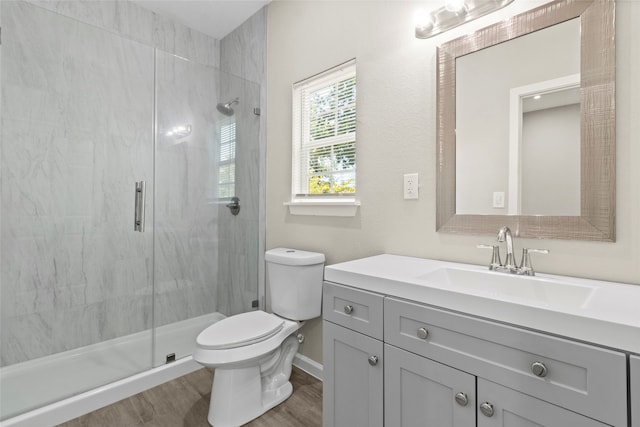 8402 Bassett St, Houston, TX 77051 - bathroom featuring a stall shower, toilet, vanity, wood finished floors, and baseboards