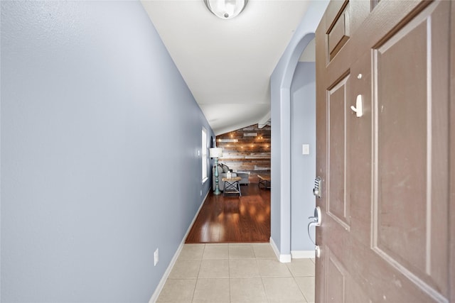 9822 Garnet Springs Dr, Iowa Colony, TX 77583 - hallway with vaulted ceiling, light tile patterned floors, baseboards, and wooden walls