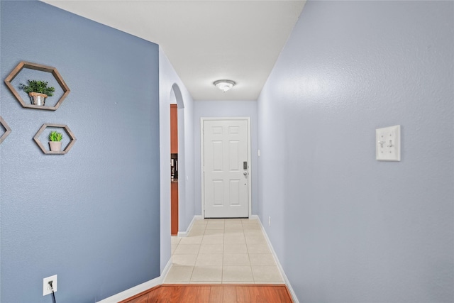 9822 Garnet Springs Dr, Iowa Colony, TX 77583 - hallway featuring arched walkways, baseboards, and light tile patterned floors