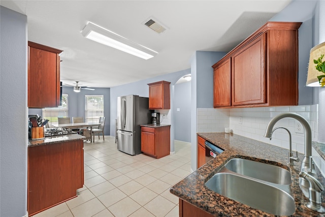 9822 Garnet Springs Dr, Iowa Colony, TX 77583 - kitchen featuring freestanding refrigerator, a sink, backsplash, and dark stone countertops