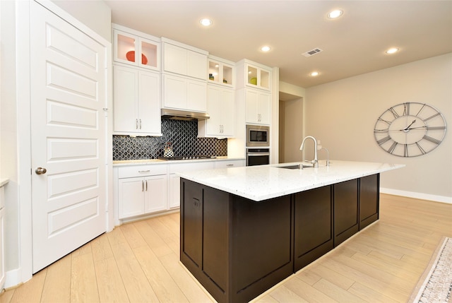 22911 Pearl Glen Dr, Richmond, TX 77469 - kitchen featuring stainless steel appliances, a sink, light wood-style flooring, under cabinet range hood, and backsplash