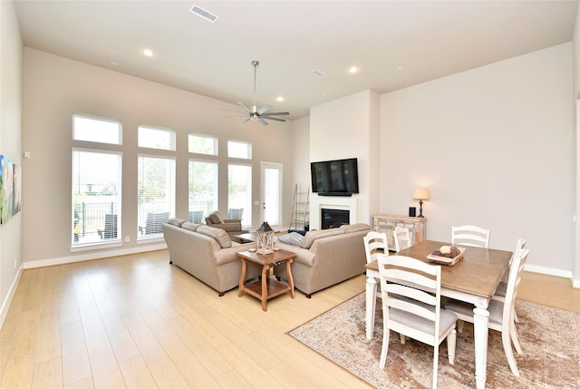 22911 Pearl Glen Dr, Richmond, TX 77469 - living area with a glass covered fireplace, light wood-style flooring, ceiling fan, recessed lighting, and baseboards