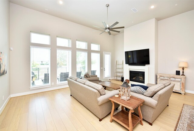 22911 Pearl Glen Dr, Richmond, TX 77469 - living room with a ceiling fan, light wood-style flooring, baseboards, a glass covered fireplace, and recessed lighting