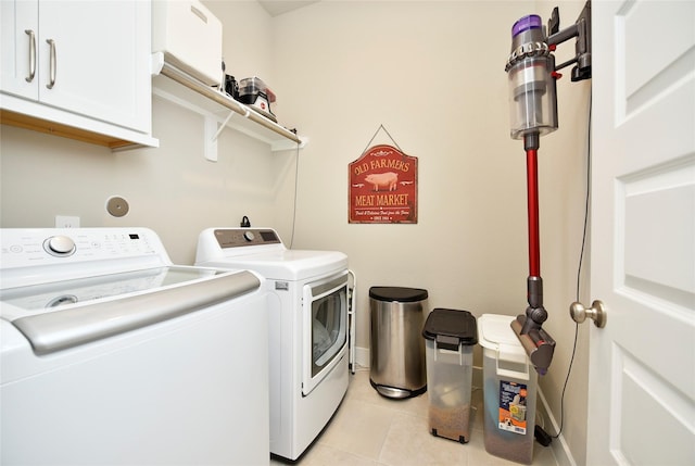 22911 Pearl Glen Dr, Richmond, TX 77469 - laundry room featuring washer and clothes dryer, cabinet space, light tile patterned floors, and baseboards