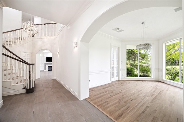 4111 Thistle Hill Ct, Sugar Land, TX 77479 - foyer with arched walkways, wood finished floors, stairs, a chandelier, and baseboards