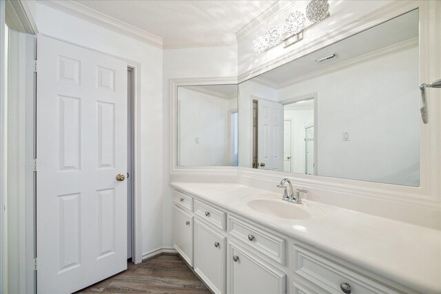 4111 Thistle Hill Ct, Sugar Land, TX 77479 - bathroom featuring vanity, wood finished floors, and ornamental molding