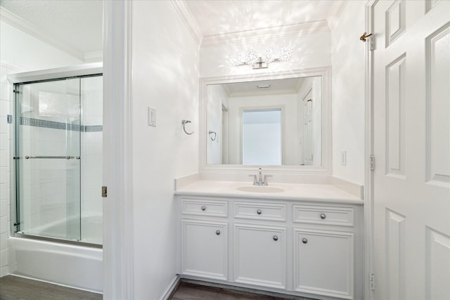 4111 Thistle Hill Ct, Sugar Land, TX 77479 - bathroom featuring crown molding, vanity, combined bath / shower with glass door, baseboards, and wood finished floors