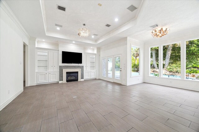 4111 Thistle Hill Ct, Sugar Land, TX 77479 - unfurnished living room with a raised ceiling, a chandelier, recessed lighting, crown molding, and a glass covered fireplace