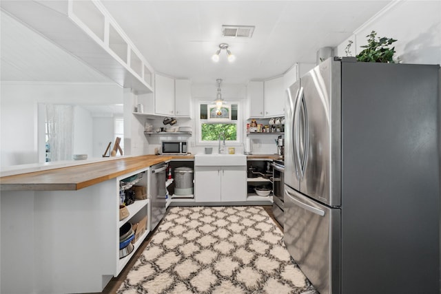 480 Johnson Rd, Coldspring, TX 77331 - kitchen featuring open shelves, appliances with stainless steel finishes, butcher block countertops, a sink, and white cabinetry