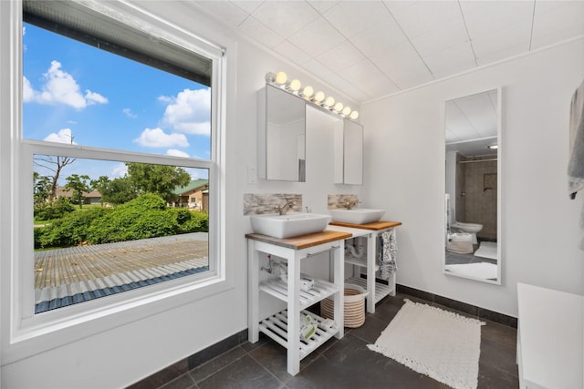 480 Johnson Rd, Coldspring, TX 77331 - bathroom featuring a shower, baseboards, and double vanity