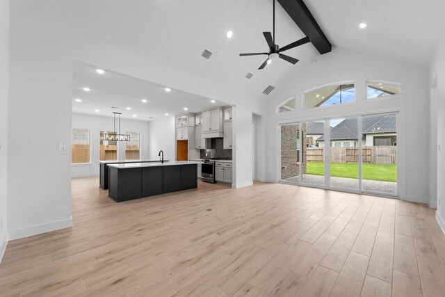 12834 Forest Garden Ct, Conroe, TX 77302 - unfurnished living room featuring beam ceiling, light wood finished floors, a ceiling fan, high vaulted ceiling, and baseboards