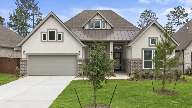 12834 Forest Garden Ct, Conroe, TX 77302 - view of front of home featuring stucco siding, brick siding, a standing seam roof, a front lawn, and concrete driveway