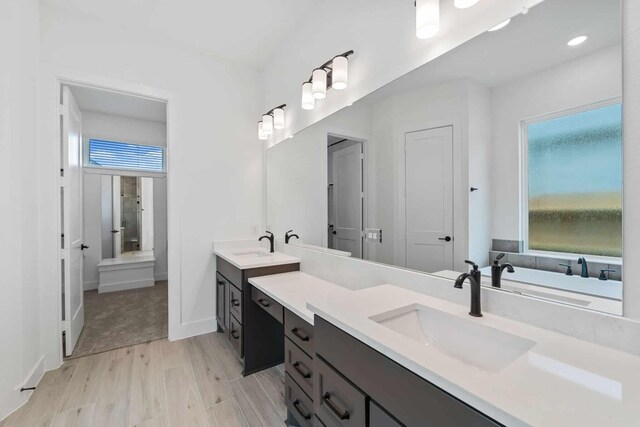 12834 Forest Garden Ct, Conroe, TX 77302 - bathroom with vanity, healthy amount of natural light, wood finished floors, and a bathtub