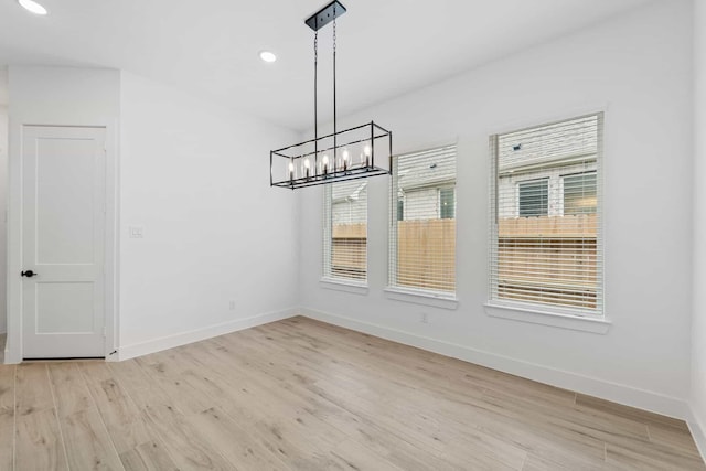 12834 Forest Garden Ct, Conroe, TX 77302 - unfurnished dining area featuring light wood-type flooring, baseboards, a chandelier, and recessed lighting