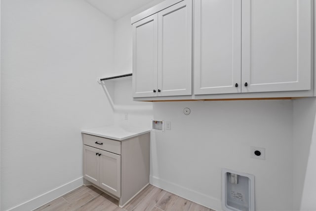12834 Forest Garden Ct, Conroe, TX 77302 - washroom featuring baseboards, hookup for an electric dryer, cabinet space, washer hookup, and light wood-style floors