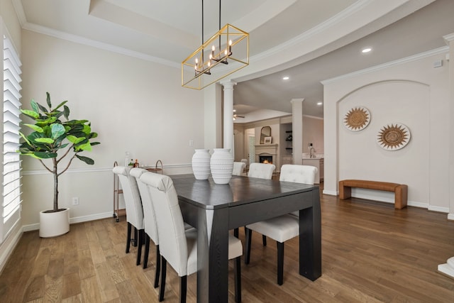 4051 Ashland Woods Dr, Spring, TX 77386 - dining area with ornate columns, wood finished floors, a warm lit fireplace, baseboards, and recessed lighting