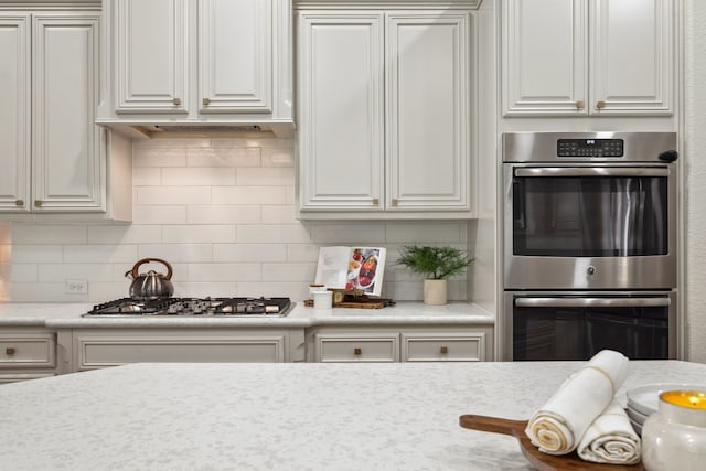 4051 Ashland Woods Dr, Spring, TX 77386 - kitchen featuring double oven, light countertops, tasteful backsplash, and white cabinetry