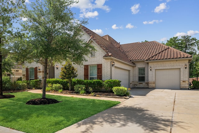 4051 Ashland Woods Dr, Spring, TX 77386 - view of front of property with an attached garage, a front yard, concrete driveway, a tile roof, and brick siding