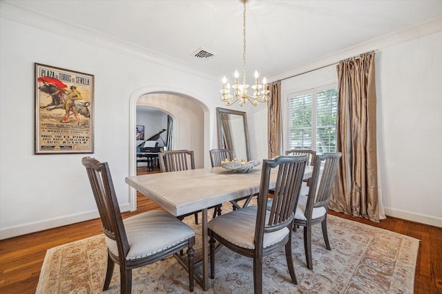 2256 Dryden Rd, Houston, TX 77030 - dining room featuring arched walkways, a chandelier, baseboards, ornamental molding, and wood finished floors