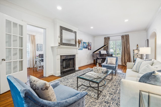 2256 Dryden Rd, Houston, TX 77030 - living room featuring ornamental molding, a premium fireplace, wood finished floors, arched walkways, and recessed lighting