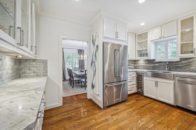 2256 Dryden Rd, Houston, TX 77030 - kitchen featuring stainless steel appliances, a sink, white cabinetry, decorative backsplash, and ornamental molding