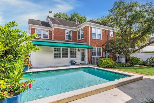 2256 Dryden Rd, Houston, TX 77030 - rear view of house with a chimney, brick siding, and central air condition unit