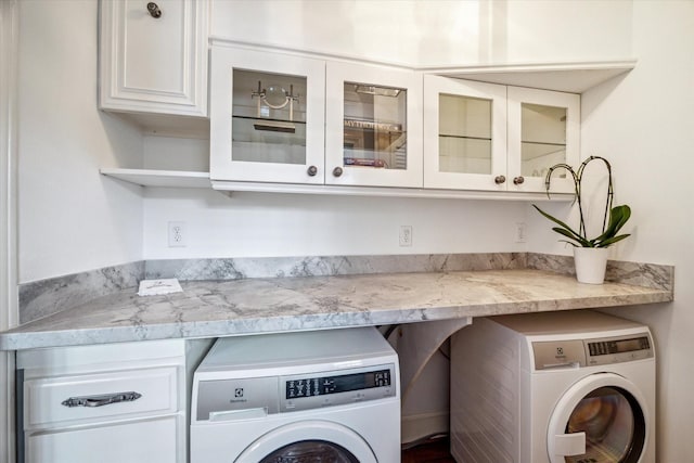 2256 Dryden Rd, Houston, TX 77030 - laundry area featuring washing machine and dryer and cabinet space