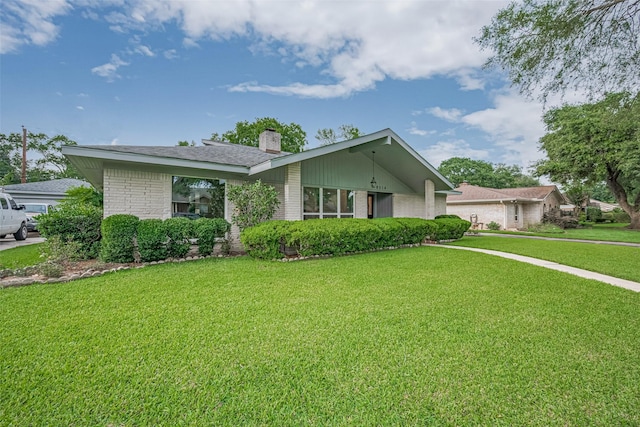 8314 Burning Hills Dr, Houston, TX 77071 - mid-century inspired home with a chimney, brick siding, and a front lawn