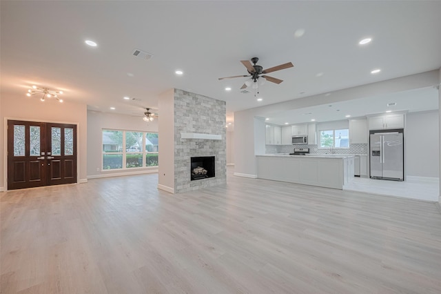 8314 Burning Hills Dr, Houston, TX 77071 - unfurnished living room featuring a ceiling fan, recessed lighting, light wood-type flooring, baseboards, and a stone fireplace