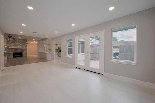8314 Burning Hills Dr, Houston, TX 77071 - unfurnished living room with french doors, a ceiling fan, recessed lighting, a stone fireplace, and baseboards
