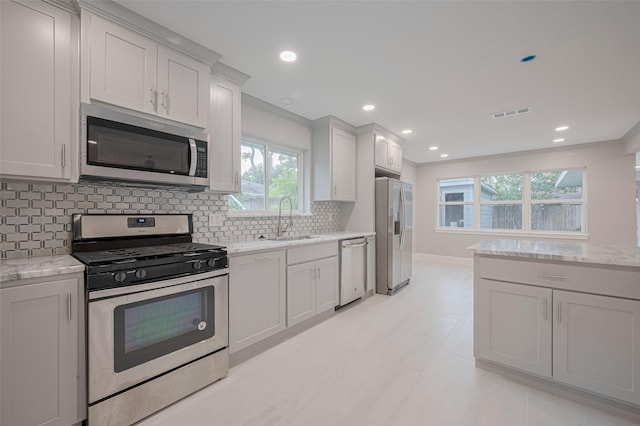 8314 Burning Hills Dr, Houston, TX 77071 - kitchen featuring stainless steel appliances, a sink, backsplash, baseboards, and light stone counters