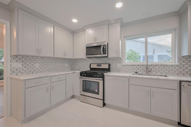 8314 Burning Hills Dr, Houston, TX 77071 - kitchen featuring appliances with stainless steel finishes, a sink, tasteful backsplash, white cabinetry, and light stone countertops