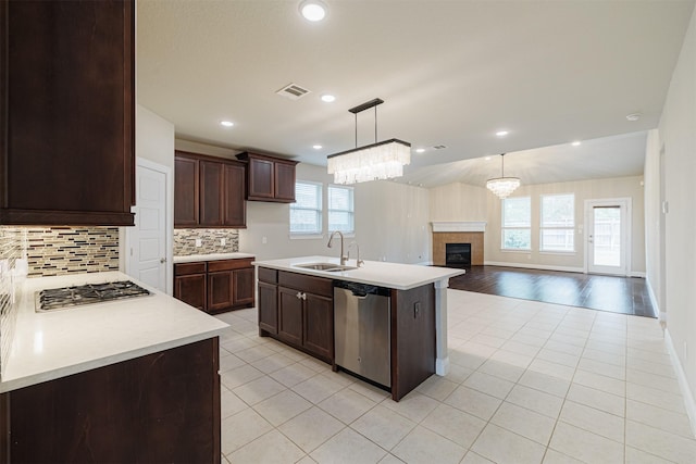 16719 Highland Country Dr, Cypress, TX 77433 - kitchen featuring stainless steel appliances, a sink, light countertops, backsplash, and a fireplace