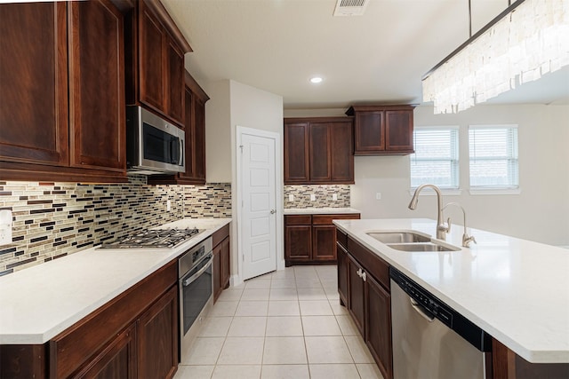 16719 Highland Country Dr, Cypress, TX 77433 - kitchen featuring stainless steel appliances, a sink, light tile patterned floors, tasteful backsplash, and light countertops